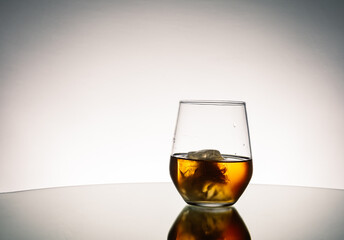 Iced Alcohol drink in a glass cup with reflection on a mirror surface