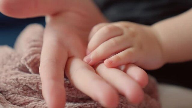 mother holds the hand of a newborn. children hand. hospital takes care of happy family medicine concept. newborn baby holding mom hand close-up. mom takes care baby in dream the hospital