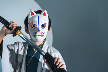 Child samurai wearing a fox mask. Japanese ninja character. - obrazy, fototapety, plakaty