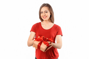 Portrait of a happy smiling girl in red t shirt holding present box and posing over white background. Cheerful brunette woman with long hair smiles, laughs and looks with joy