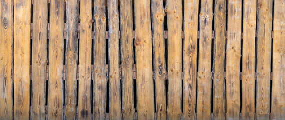 Alte gelbbraune Bretter Trennwand vor dunklem Hintergrund, Wand eines halboffenen ländlichen...