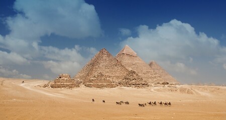 Egyptian pyramids and the camel caravan on a sunny day