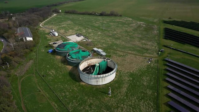 Aerial view of a natural gas tanks in the field near a solar power station, 4k
