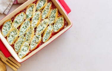 Baked pasta stuffed with cheese and spinach in tomato sauce. Vegetarian food. Italian food.