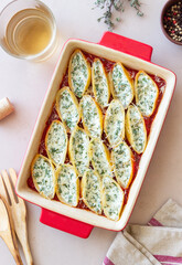 Baked pasta stuffed with cheese and spinach in tomato sauce. Vegetarian food. Italian food.