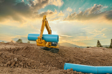 Crawler Excavator is digging in the construction site with bucket  lift up  pipe on a sunlight backgrounds.