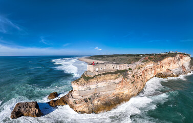 Lighthouse in Nazare, Portugal. Famous place for waves and surfing. Beach and Ocean Waves in...