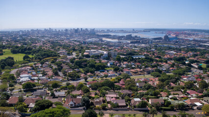 Fototapeta na wymiar A wide panoramic view of the urban area and city skyline of Durban with harbor and sea in the distance.