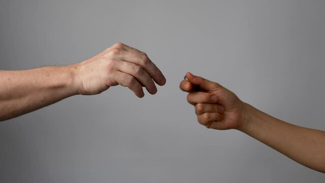 Man hand giving keys to woman, grey background