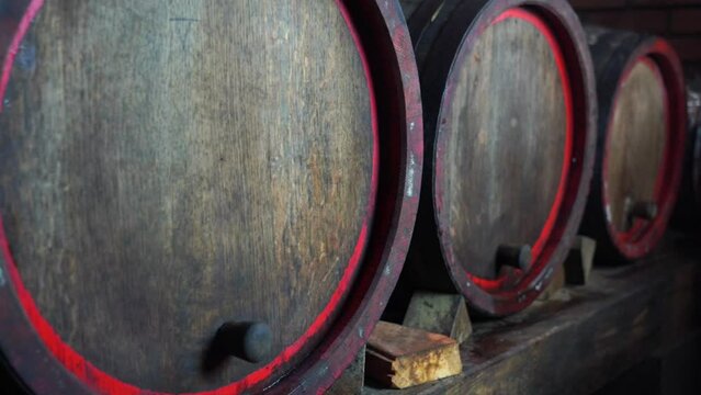 Aged wooden barrels with a wine , brandy or whiskey in a big warehouse 