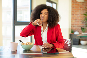 pretty afro black woman feeling cross,showing thumbs down. having breakfast concept