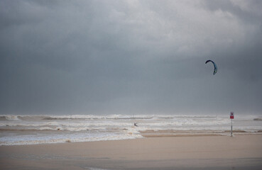 Obraz premium Stormy Mediterranean Sea and Cloudy Sky in Tel Aviv, Israel. Man with Power Kite