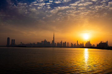 Fototapeta na wymiar Dubai skyline during sunset. Dubai's skyline cast long shadows, creating a stunning silhouette against the evening sky.