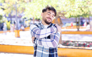 young handsome man feeling in love, smiling, cuddling and hugging self, staying single, being...