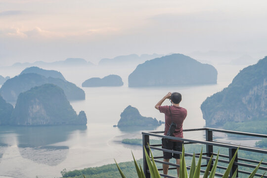 A photographer photographs a beautiful view from the Samet Nanghse observation deck in Thailand.Morning view of the blue mountains and stones in the water in Thailand, mysterious beauty. Tourism