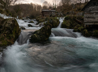 Mountain river with mossy rocks and wooden watermills, river Krupa in Krupa na Vrbasu