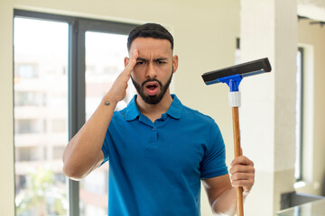 young  adult man looking happy, astonished and surprised. windows washer concept