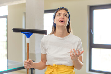 young pretty woman screaming with hands up in the air. windows washer concept