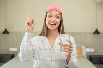 young pretty woman feeling like a happy and excited genius after realizing an idea. water glass...