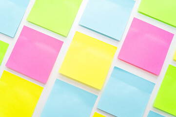 Post it of various colors stuck to a white surface. Notes and memos.