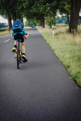 Kleiner Junge sprintet auf einer Fahrradtour durch Niedersachsen in den Sommerferien, Deutschland