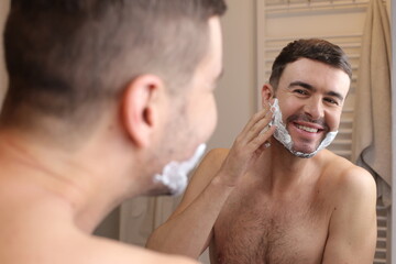 Handsome man applying shaving foam 