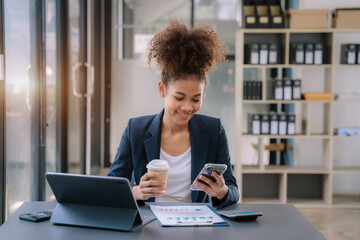 Happy black businesswoman using a smartphone in office.