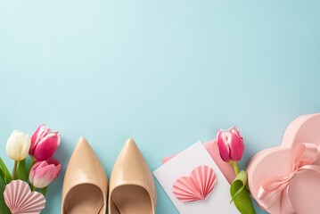 Elegant Mother's Day concept. Top view flat lay of high-heels, present box, tulips, postcard on pastel blue background with plenty of space for text or advert