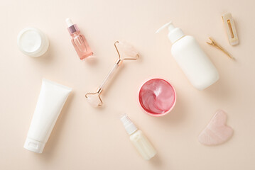 Cosmetics concept. A stylish top view flat lay of cream bottles, serum pumps, and face rollers on a...