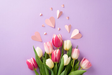 Mother's Day surprise concept. Top view flat lay of pretty tulip flowers, paper hearts on a soft...