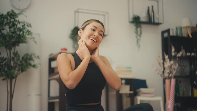 Smiling fitness blogger talking on camera and showing neck exercise, workout