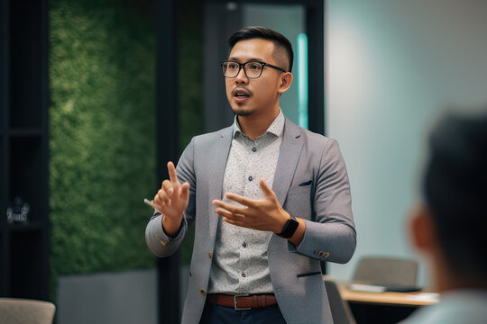 A fictional person. Charismatic Speaker Giving Business Presentation in Coworking Space, Southeast Asia