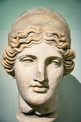 Obraz premium Head and shoulders detail of the ancient woman with beard sculpture. Antique face with whiskers statue isolated on green background