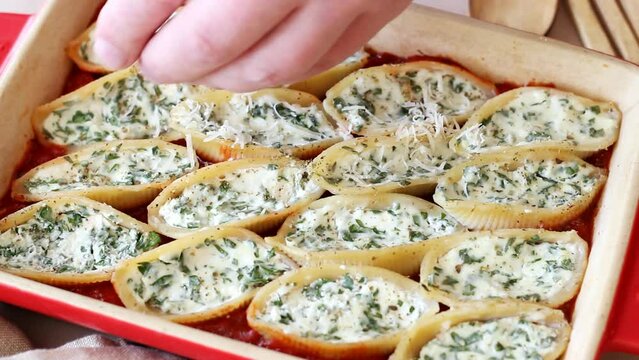 Baked pasta stuffed with cheese and spinach in tomato sauce. Vegetarian food. Italian food.