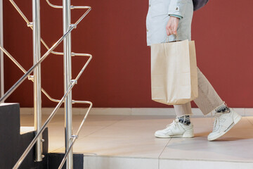  person carries food delivery in paper bag for an online buyer. delivery of orders from online store to door. working as courier in restaurant or bakery