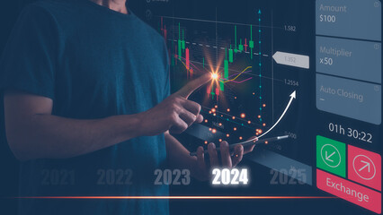 Businessman is using smartphone and virtual hologram stock, invest in trading, planning analyze indicator and strategy for year 2024 buy and sell, Stock market, Business growth,  concept.