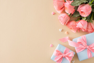 Happy Mother Day idea. Top view composition of present boxes bouquet of pink roses and small hearts on isolated pastel beige background with blank space