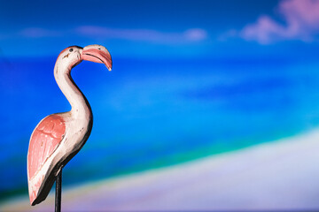 wooden flamingo and sea and a beach in the background 