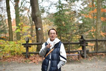 Young woman smiles during an autumn hike in a forest park