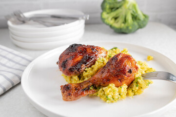 Glazed chicken with curried rice and broccoli on a plate