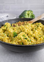 Curried brown rice with broccoli in a skillet
