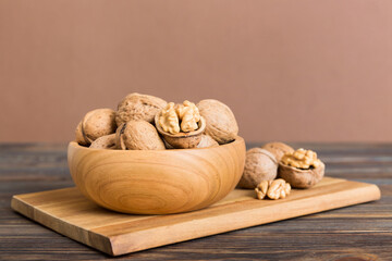 Fresh healthy walnuts in bowl on colored table background. Top view Healthy eating bertholletia concept. Super foods