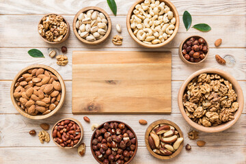 mixed nuts in wooden bowl. Mix of various nuts on colored background. pistachios, cashews, walnuts, hazelnuts, peanuts and brazil nuts