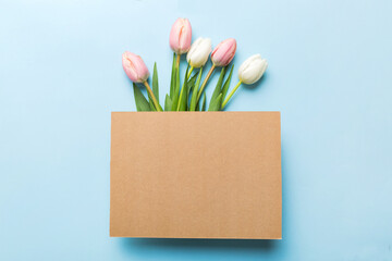 Composition with blank card and beautiful flowers tulip on coloredbackground. top view with space for you desing