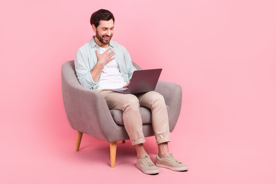 Full length photo of charming impressed man wear turquoise shirt video conference modern gadget empty space isolated pink color background