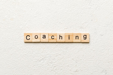 COACHING word written on wood block. COACHING text on table, concept