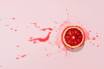 juicy red orange or grapefruit slice on pastel pink background minimalist summer art concept