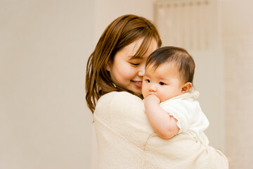 室内で赤ちゃんを抱っこする幸せいっぱいの母親