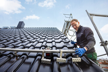 Craftsman installing the solar panel mounting system on a roof