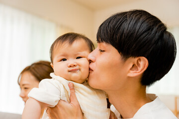 0歳児の赤ちゃんにキスする30代の父親の男性